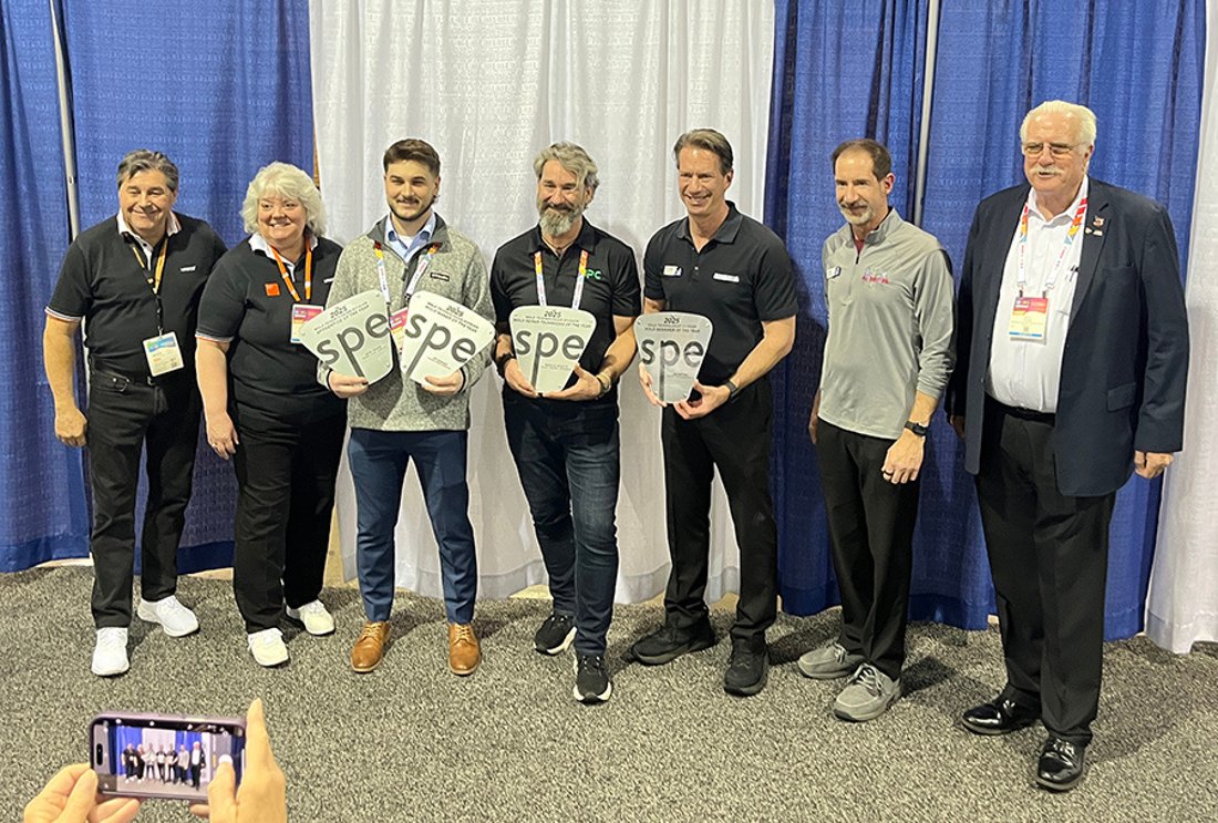 MTD board members and award recipients holding SPE-shaped trophies at a past awards presentation
